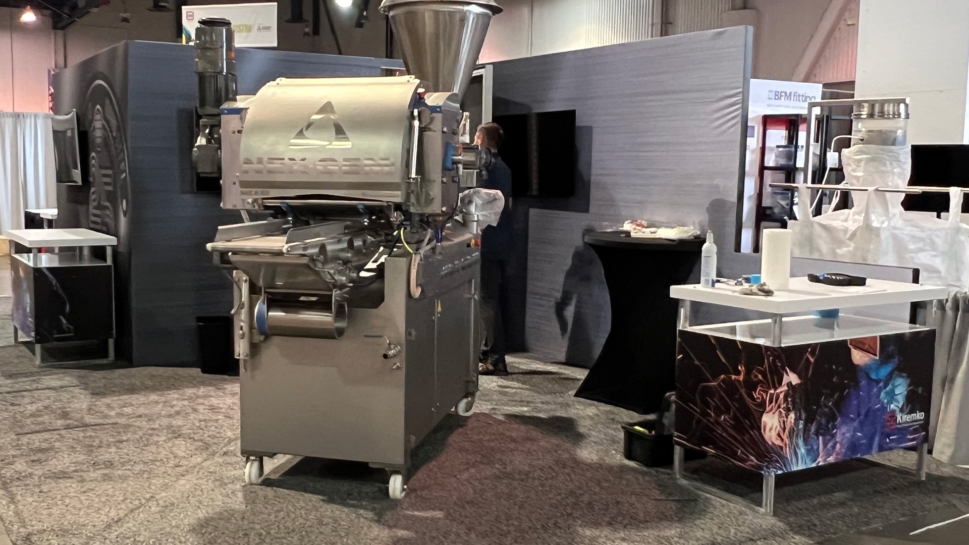 Image of a large metal steel working machine for Idaho Steel's trade show booth at Pack Expo 2023 in Las Vegas, NV, United States. Features custom trade show display counters by TSD Counters in Boise, ID.